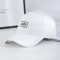 White baseball cap with AD embroidery on a minimalist interior background with books - White + Black Label