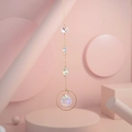 Macro detail of iridescent teardrop crystal pendant on gold metal ring with light prisms - US 8