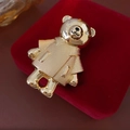 Macro detail of a gold bear brooch with sparkling rhinestones on a red velvet jewelry box - Gold Panda/Bear