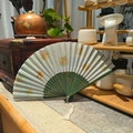 Ventaglio pieghevole verde chiaro con motivi floreali gialli e nappe bianche - Otto Immortali B