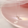 Elegant silver heart pendant necklace with faceted finish on a soft pink ceramic tray - Heart Bean Necklace