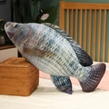 Detailed realistic fish plush pillow showing lifelike scales and fins on a cozy bed - 30cm / Tilapia