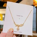 Collier doré avec pendentif nœud et pampilles de marguerite en cristal sur carte - Marguerite à Nœud Papillon Dorée