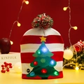 Detail of knitted Christmas hat with LED lights, striped pattern and a fuzzy pom-pom - Christmas Tree