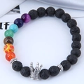Close-up of lava stone bead bracelet featuring 7 chakra beads and a silver crown charm - Crown / Black/Multicolor