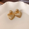 Detailed view of gold heart earrings with stripe texture on a ceramic tray - 29# Silver Earring Post - Gold - Heart