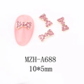 Detail of 10x5mm gold bow nail charm with pink rhinestones for festive manicure art - A688