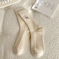 Beige cotton crew socks with black bow embroidery on a textured background - One Size / Beige