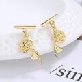 Elegant gold rose stud earrings with delicate petals and leaf on ceramic plate - Gold