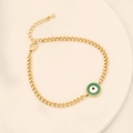 Dettaglio del bracciale a catena dorata con ciondolo malocchio verde su vassoio crema - Stile Malocchio Dorato (3#眼睛)