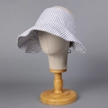 Detail of striped cotton linen sun hat with wide brim on wooden mannequin head stand - M(56-58cm) / White (E25024)