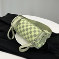 Green and grey checkerboard cylinder bag with wide woven strap in trendy crossbody style - Green