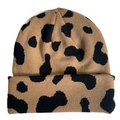 Detailed view of brown cow print knit beanie hat with black spots on white background - Cow Print - Khaki