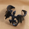 Macro detail of gothic style black dragon wing ring on bronze satin background - Black Dragon Bat Wing