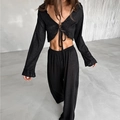 Close-up of black knit two-piece set featuring a tie-front crop top and wide-leg trousers - S / Black