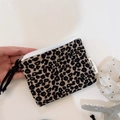 Close-up of leopard print mini pouch with white zipper and a woven black puller detail - Black and Grey Leopard