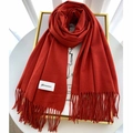 Detail of solid orange cashmere scarf with tassel edges and Gerunsi brand label - Orange Red