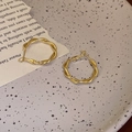 Modern gold twisted hoop earrings with irregular texture displayed on a decorative plate - Gold Twist Hoops (2#)