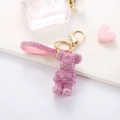 Close-up of pink rhinestone bear keychain with matching leather strap and gold hardware - Pink