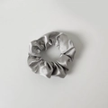 Detailed view of a silver grey satin scrunchie featuring smooth silk-like texture and folds - Without Card / Gray