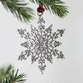 Silver metal snowflake ornament with red ribbon hanging on a Christmas tree branch - Snowflake Antique Silver / Antique Silver