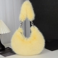 Macro detail of plush yellow faux fur texture with large silver chain on shoulder bag - Yellow