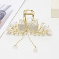 Detail of rhinestone bow hair claw with gold flower tassels and pearl accents - Gold Bowknot