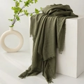 Green linen cotton scarf with fringed edges displayed on white block with plant decor - Moss Green