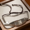 Detailed close-up of retro silver fish pendant on adjustable brown braided rope bracelet - Single Fish Bracelet