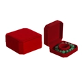 Macro view of red velvet octagonal jewelry box showcasing a green bead bracelet - Red