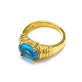 Detailed view of an oval blue gemstone ring with gold-plated textured band on white background - US 6 / Gold Aqua Blue Gemstone