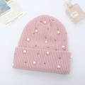 Detail of pink ribbed knit beanie featuring elegant pearl and metallic bead embellishments - Pink