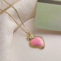 Elegant gold necklace with a pink heart enamel pendant on soft white fabric background - Pink