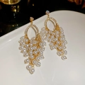 Dettaglio di orecchini a grappolo d'oro con perle bianche e strass scintillanti - Perno in Argento S925 / Oro