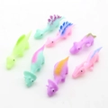 Lot de 7 jouets dinosaures lance-pierres colorés aux tons pastels sur fond blanc - Dinosaure Lance-pierre