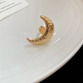Detailansicht eines goldenen Mondrings mit Hammerschlag-Textur auf weißem Keramikteller - Gold Hammerschlag-Mond-Stil (3#)
