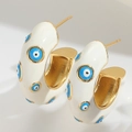 Detail of wide C-shaped hoop earrings with white enamel and blue evil eye patterns - White C-Shape Evil Eye