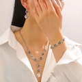Detail of silver jewelry set with square black stones on a model in a white shirt - Bracelet Earrings And Long Necklace Set (29)