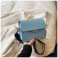 Close-up of sky blue PU leather square crossbody bag with black wide fabric strap - Light Blue