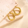 Créoles torsadées en finition or 18 carats présentées sur une surface en pierre mate - EH083/Créoles Torsadées en Spirale