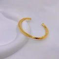 Dettaglio del bracciale rigido dorato a torsione Mobius su base bianca - Oro Grande