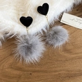 Détails de boucles d'oreilles cœur noir et pompons gris sur fond bois sombre - Cœur Noir Boule de Poils Grise Style Long