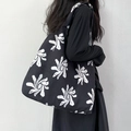 Detail of high-capacity black canvas tote bag with white floral pattern on shoulder - Black