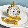 Vintage golden Alice themed flip pocket watch with chain on an elegant gift box background - Gold