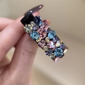 Vue macro d'une barrette rectangulaire avec des strass colorés sur une base noire - Bleu Lac Multicolore