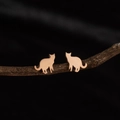 Elegant rose gold cat silhouette stud earrings displayed on a dark textured branch - Cat Rose Gold