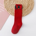 Close-up of red knit socks with a festive red-green bow and small golden bell - L 1-3 Years Old / Red (Red Green Bell)