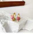 Détail de breloques cœur rose sur créoles dorées posées sur roche blanche et plateau - Boucles d'Oreilles Coeur Émail Contrasté - Blanc Rose