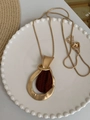 Detail of geometric teardrop pendant with matte gold frame and wood grain inlay on snake chain - Necklace - Gold