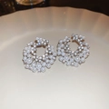 Detailed view of silver flower earrings with pearls and crystals on a ceramic tray - Silver Irregular Beaded Halo Style (116#)